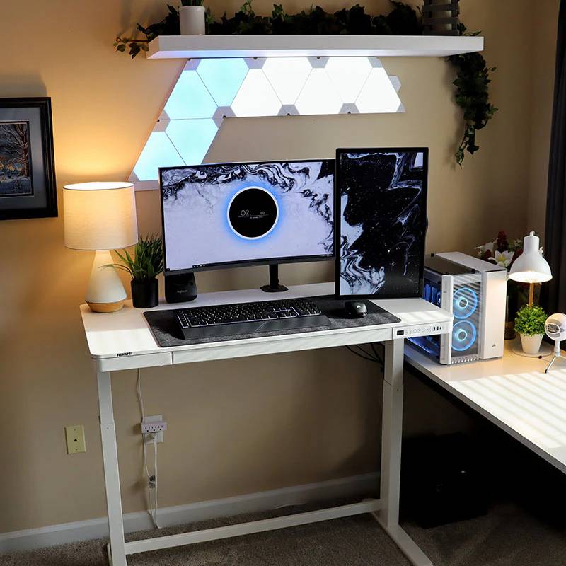 An adjustable desk with a gaming setup