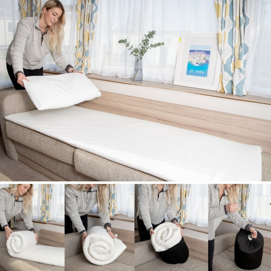 A woman folding up the travel mattress topper